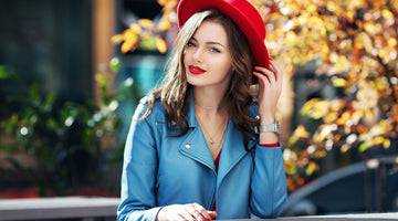 A lady wearing a red fabric hat and blue leather jacket sitting in the park