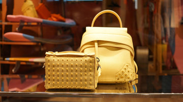 A yellow leather purse and matching handbag in a shop window