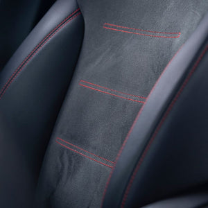 Close-up of a dark grey fabric car seat panel with red stitching.