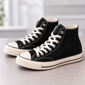 Black canvas high-top trainers resting on a worktop after protector application.