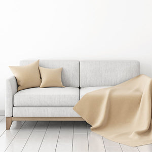 Light grey fabric sofa with cream cushions and a pale yellow throw.