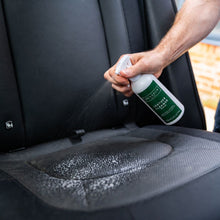 Renapur Leather Cleaner Spray being applied to a black leather car seat.