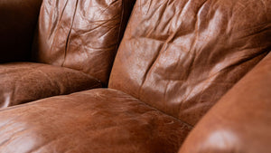 Leather sofa showing natural signs of wear and dryness before conditioning